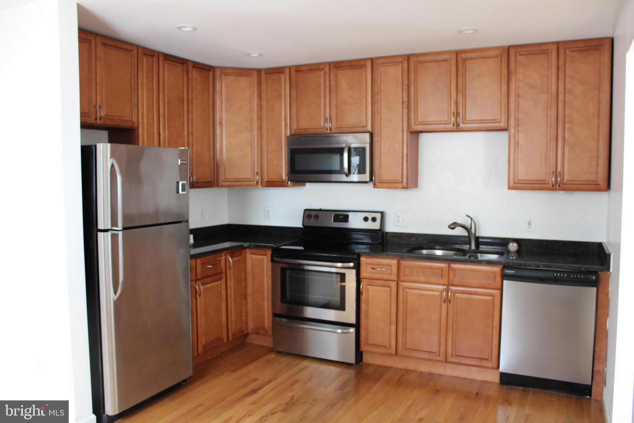19115 Wayne Drive Triangle, VA 22172 - Photo 13 of 47 a kitchen with granite countertop wooden cabinets and stainless steel appliances
