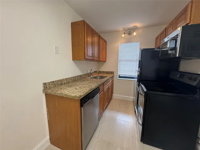 a kitchen with granite countertop stainless steel appliances and wooden cabinets