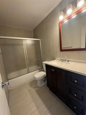 a bathroom with a sink vanity mirror and toilet