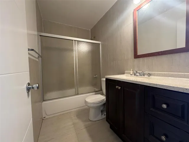 a bathroom with a sink vanity mirror and toilet