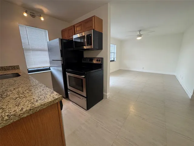 a kitchen with stainless steel appliances granite countertop a sink and a stove