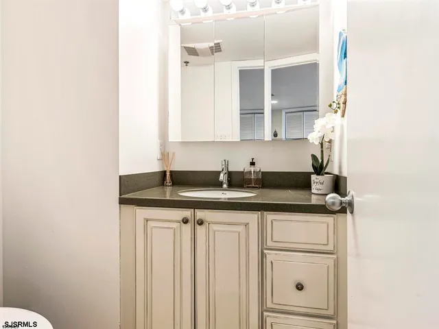 a bathroom with a granite countertop sink and a mirror