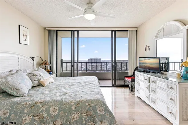 a bedroom with a bed and a flat tv screen on the dresser