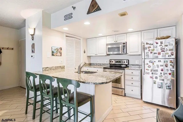 a kitchen with stainless steel appliances granite countertop a stove and a refrigerator