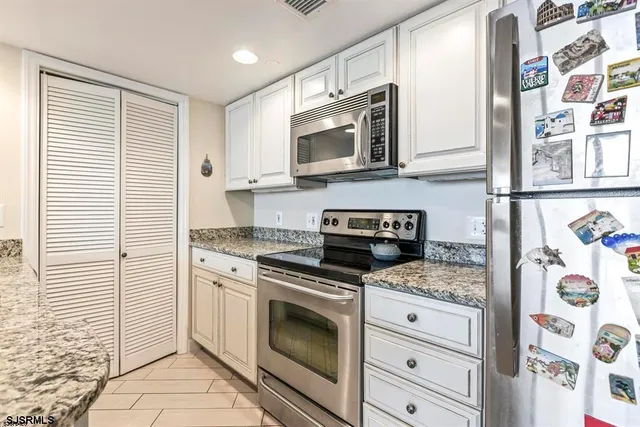 a kitchen with stainless steel appliances granite countertop a stove and a microwave