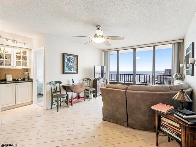 a living room with furniture two window and a dining table