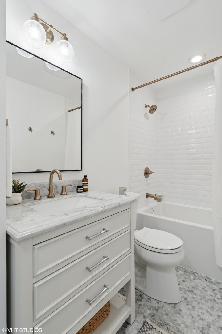 1332 West Madison Street, Unit 3E Chicago, IL 60607 - Photo 13 of 14 a bathroom with a granite countertop sink toilet a large mirror and shower