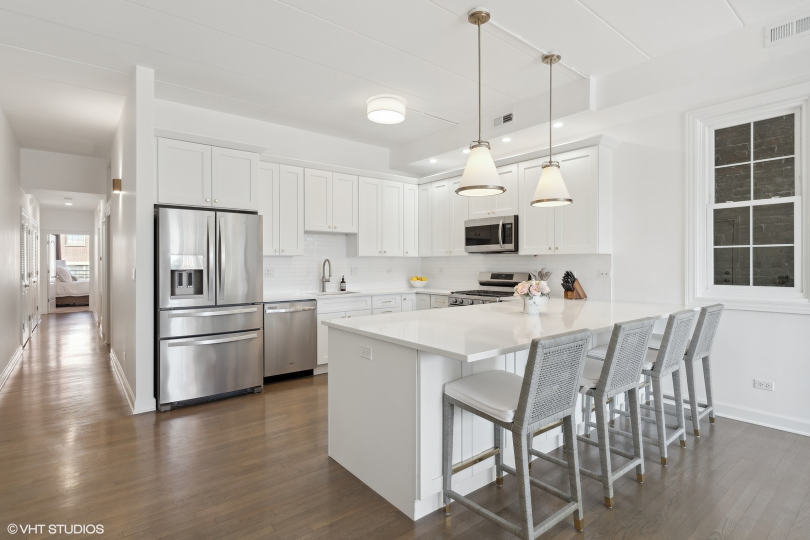 1332 West Madison Street, Unit 3E Chicago, IL 60607 - Photo 5 of 14 a kitchen with stainless steel appliances kitchen island a refrigerator and microwave