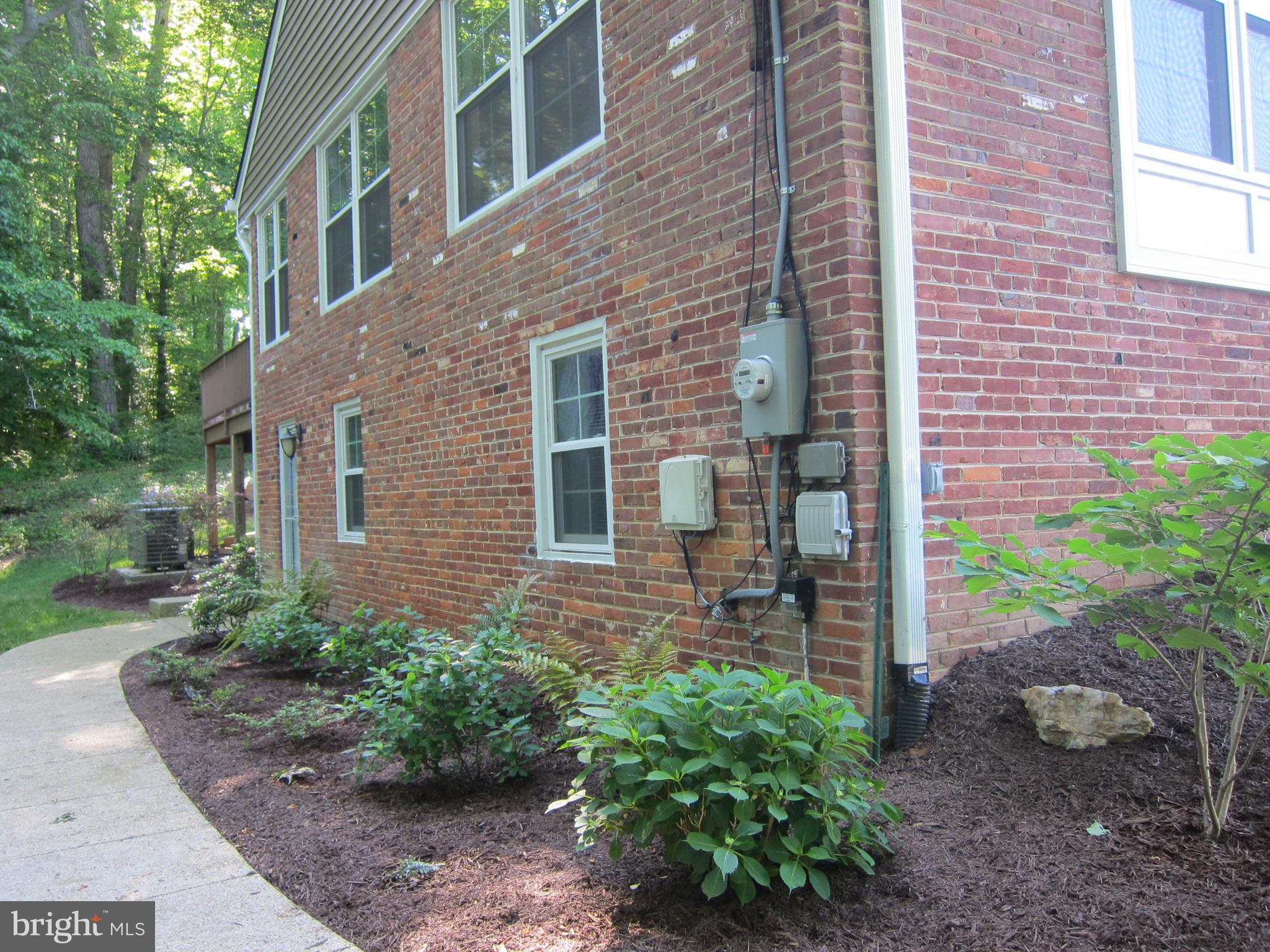 8543 Howell Road Bethesda, MD 20817 - Photo 3 of 24 a view of a brick house with a yard and plants