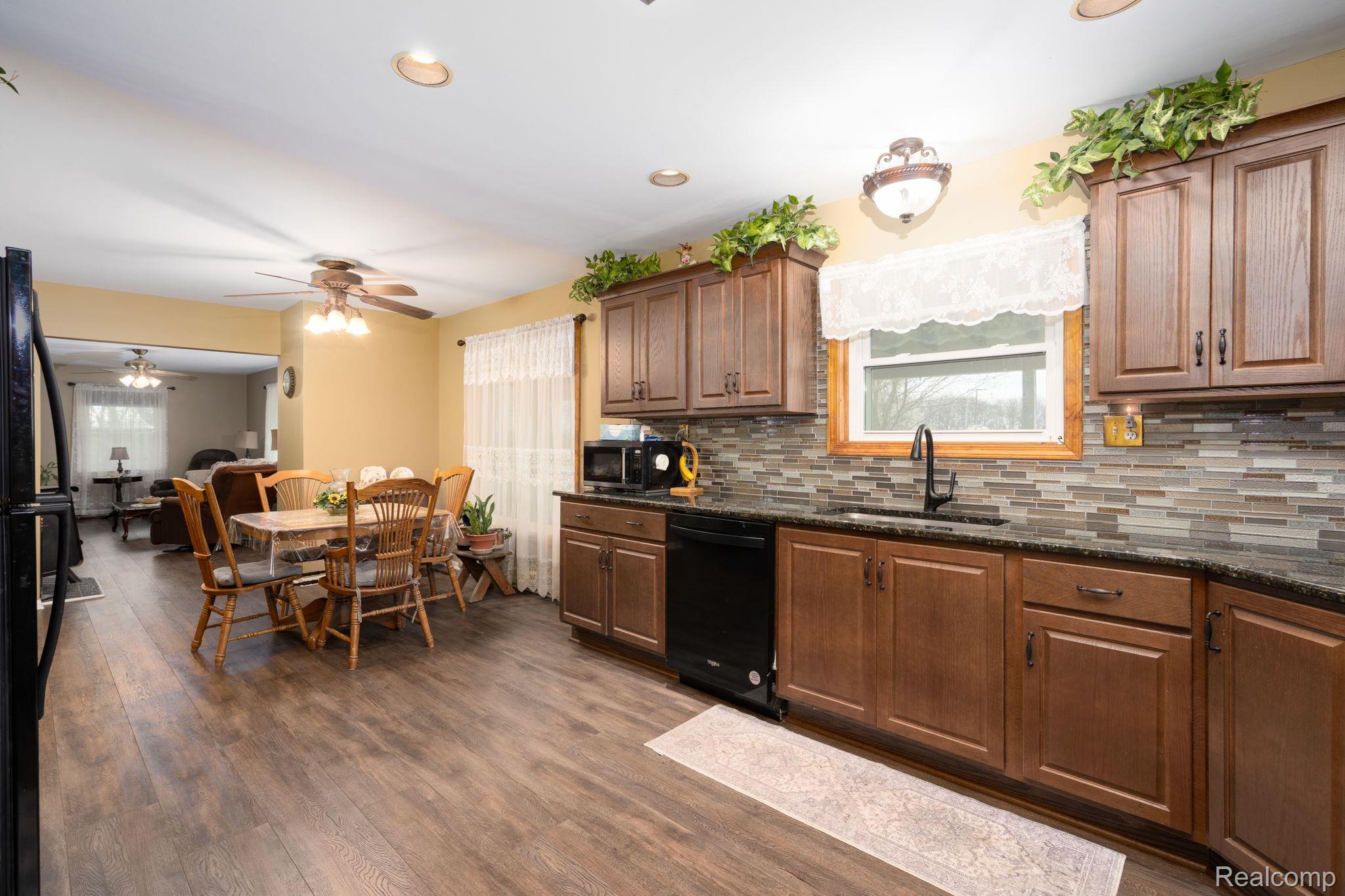 2890 Graham Road Imlay City, MI 48444 - Photo 18 of 33 Kitchen with black appliances, dark stone countertops, recessed lighting, dark wood finished floors, and a ceiling fan
