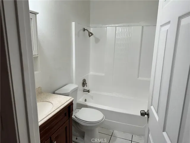 a bathroom with a granite countertop bathtub shower and toilet