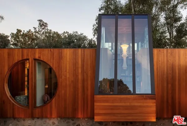 a view of a house with backyard and wooden fence