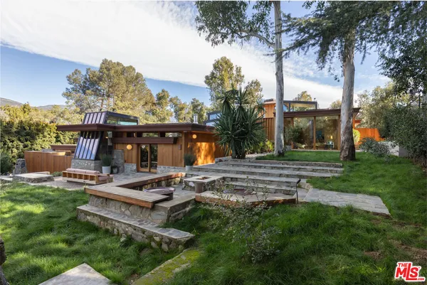 a view of a house with backyard porch and sitting area