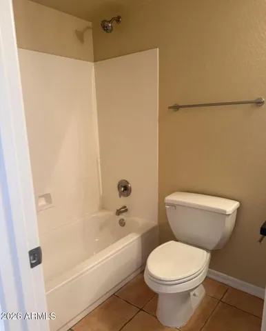 a white toilet sitting next to a bath tub