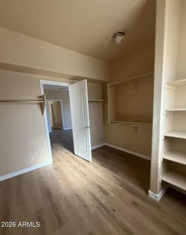a view of an empty room with closet and a window
