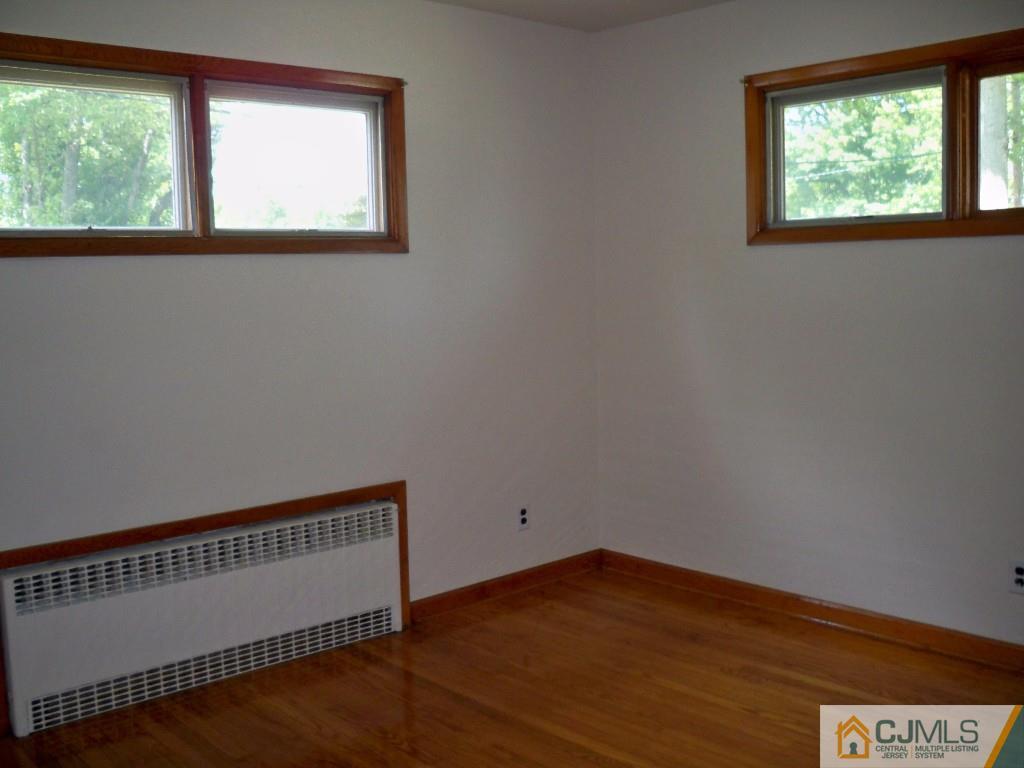 111 Kimberly Road Colonia, NJ 07067 - Photo 13 of 18 a view of an empty room with wooden floor and a window