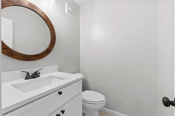 a bathroom with a sink a toilet and a mirror