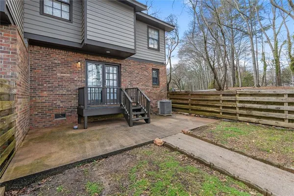a view of backyard with wooden fence and a large tree