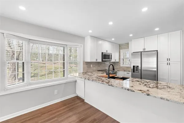 a kitchen with stainless steel appliances granite countertop a stove a sink a refrigerator and a oven