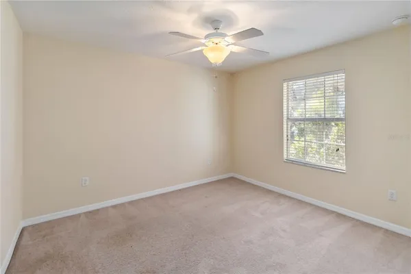 an empty room with a window and a fan