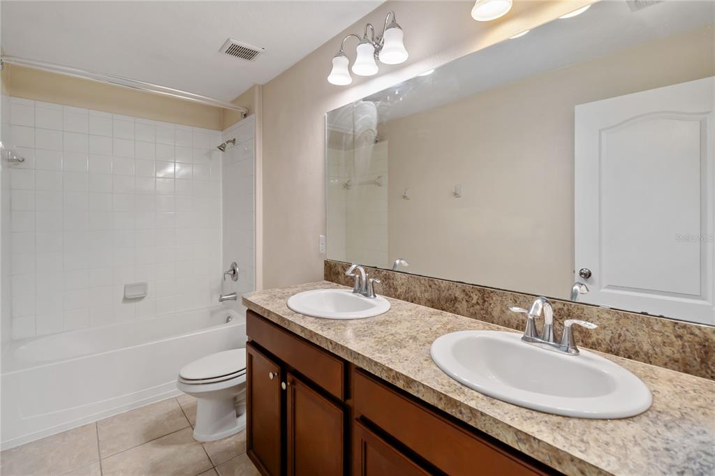 1379 Vasey Road Apopka, FL 32703 - Photo 17 of 21 a bathroom with a granite countertop double vanity sink and a mirror