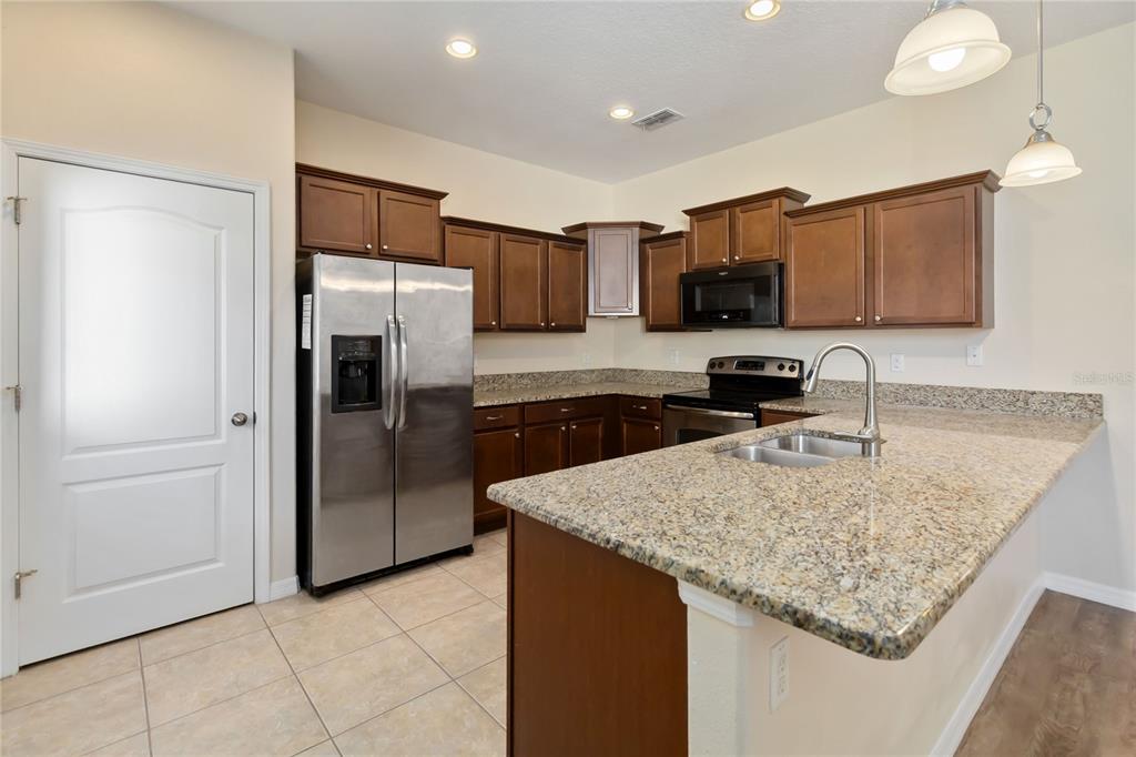 1379 Vasey Road Apopka, FL 32703 - Photo 3 of 21 a kitchen with stainless steel appliances granite countertop a refrigerator and a sink