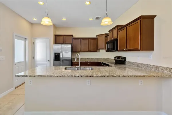 a kitchen with stainless steel appliances granite countertop a sink a stove and a microwave