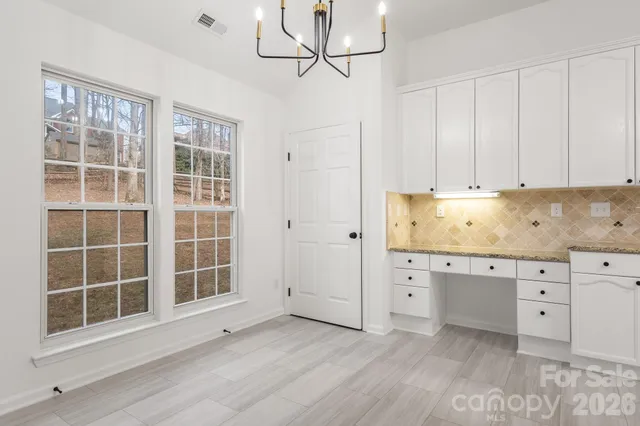 an empty room with windows and cabinet