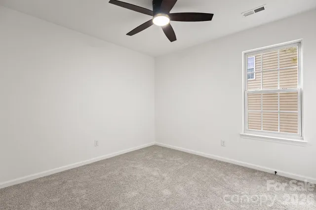 an empty room with a window and a fan