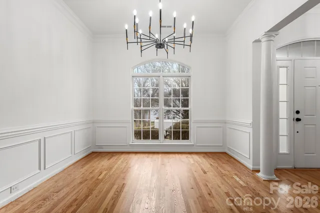 a view of empty room with wooden floor and window
