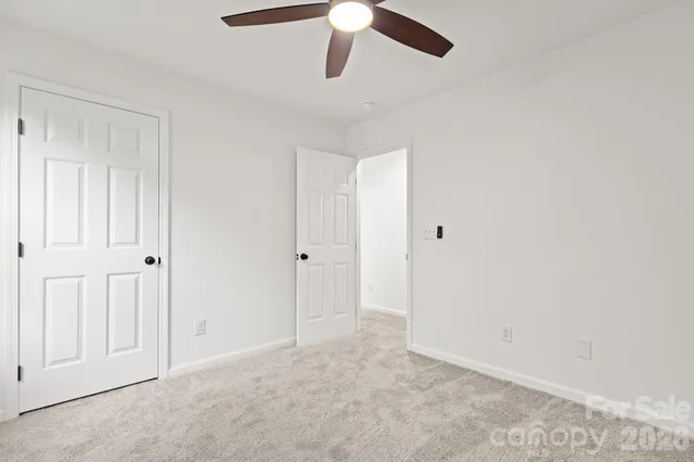 an empty room with chandelier fan