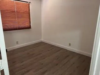 an empty room with wooden floor and a window