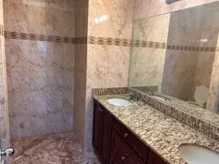 a bathroom with a granite countertop sink and shower