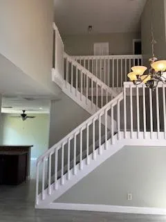 a view of staircase with railing and white walls
