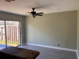 a view of room with a ceiling fan and wooden floor
