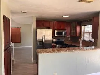 a kitchen with stainless steel appliances granite countertop a sink refrigerator and microwave