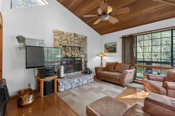 a view of a dining room with furniture a fireplace and wooden floor