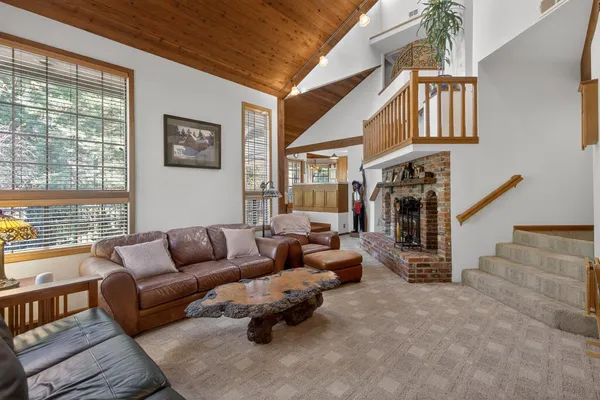 a living room with furniture a flat screen tv and a floor to ceiling window