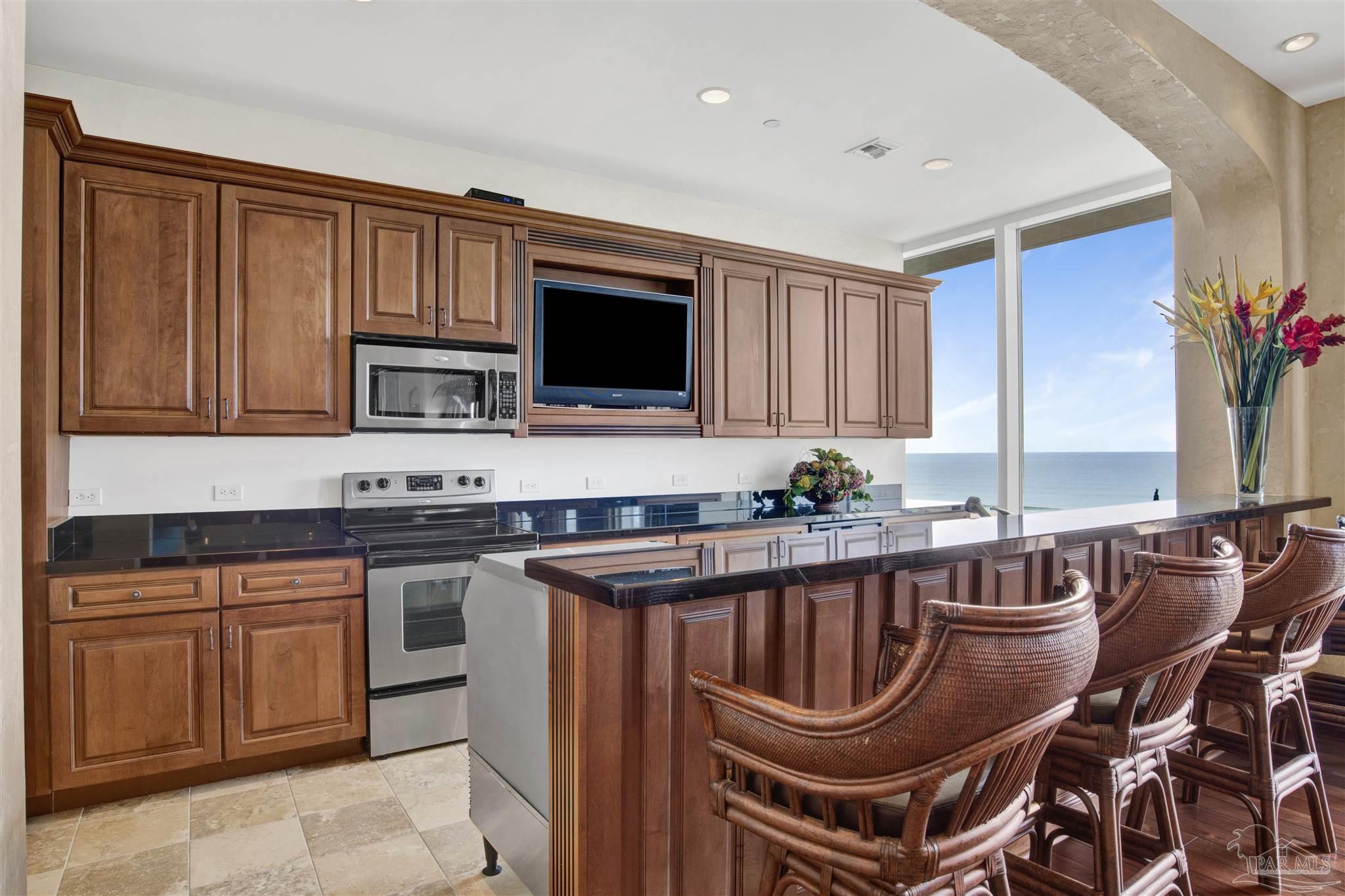 14455 Perdido Key Drive, Unit 601 Perdido Key, FL 32507 - Photo 48 of 62 a kitchen with stainless steel appliances granite countertop a stove a sink dishwasher a microwave oven with granite countertops and cabinets