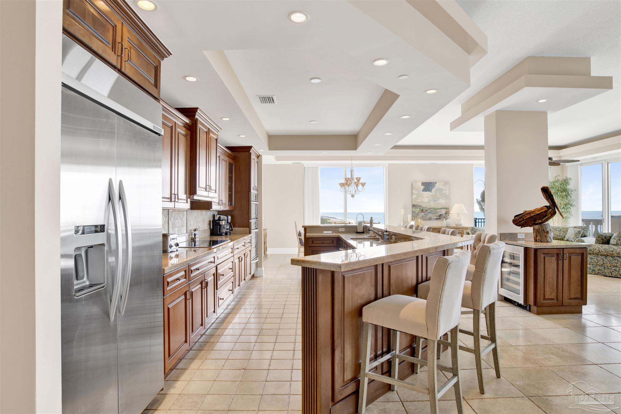 14455 Perdido Key Drive, Unit 601 Perdido Key, FL 32507 - Photo 5 of 62 a kitchen with stainless steel appliances kitchen island granite countertop a table chairs sink and cabinets