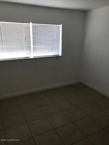 a view of a small space with wooden floor and a window