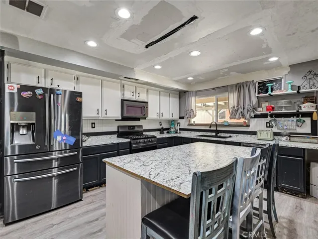 a kitchen with kitchen island granite countertop stainless steel appliances and view living room