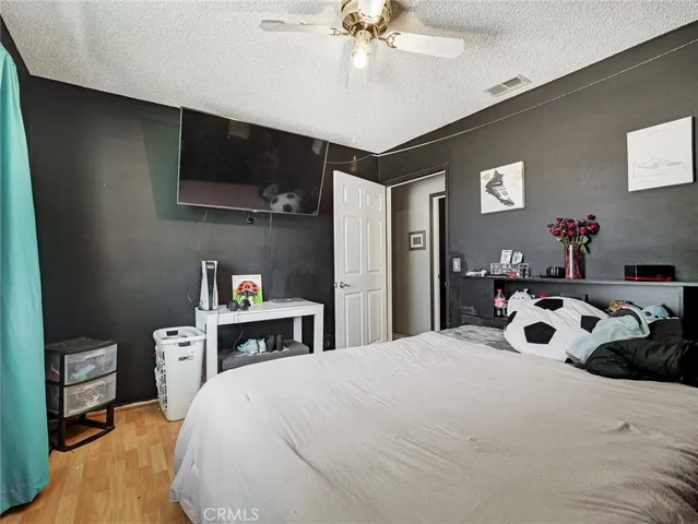 a bedroom with a bed and a flat tv screen on dresser