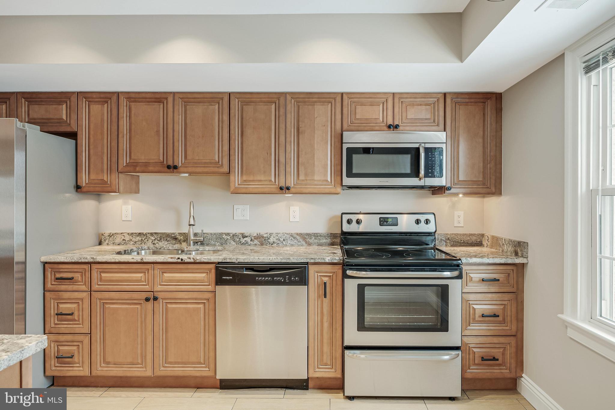 814 Geranium Street Northwest Washington, DC 20012 - Photo 14 of 51 a kitchen with granite countertop a stove top oven microwave and cabinets