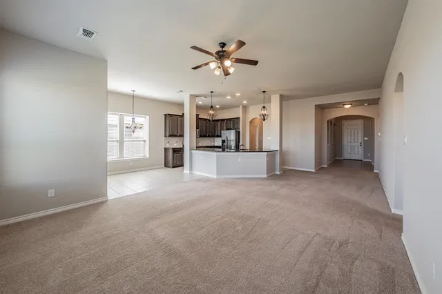 a view of a livingroom with a ceiling fan window and a kitchen