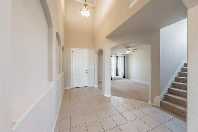 a view of a hallway with entryway and stairs