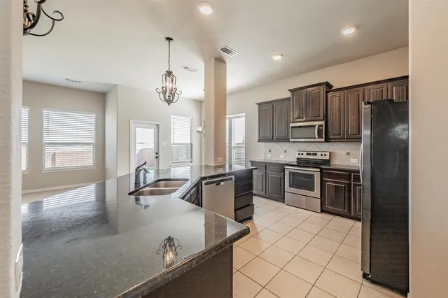a kitchen with kitchen island a counter top space appliances and a counter top space