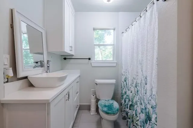 a bathroom with a toilet sink and mirror