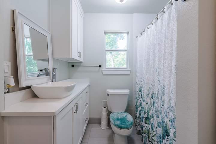 1104 Perry Road Austin, TX 78721 - Photo 12 of 15 a bathroom with a toilet sink and mirror