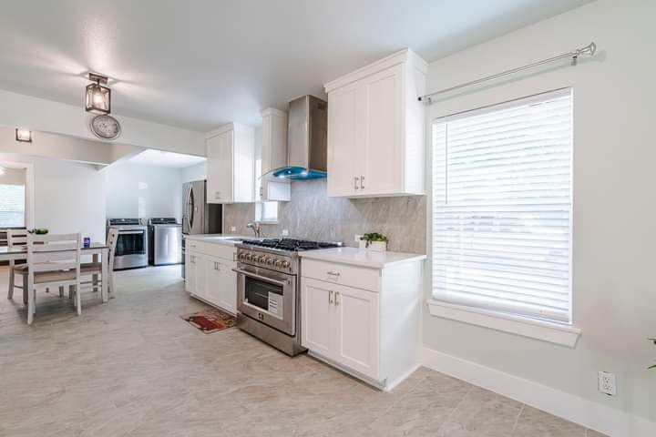 1104 Perry Road Austin, TX 78721 - Photo 7 of 15 a kitchen with stainless steel appliances granite countertop a stove a sink and white cabinets